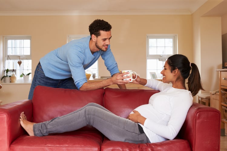 Husband giving green tea to his pregnant wife